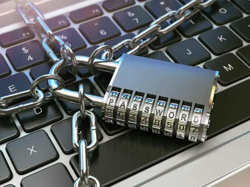 A padlock and chain laying on a keyboard.