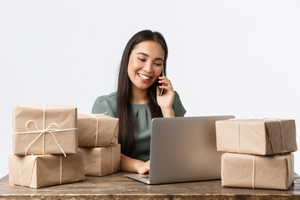 woman business owner with a laptop surrounded by packages